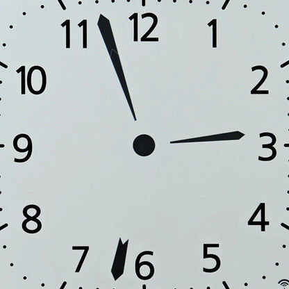 Nahaufnahme der weißen Funk-Wanduhr: schwarze Zeiger, Punkte als Minutenmarken, Ziffern 1–12.