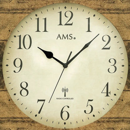 AMS Wanduhr Großaufnahme: beige Zifferblatt, schwarze Zeiger, Funkuhr-Symbol, Holzstruktur