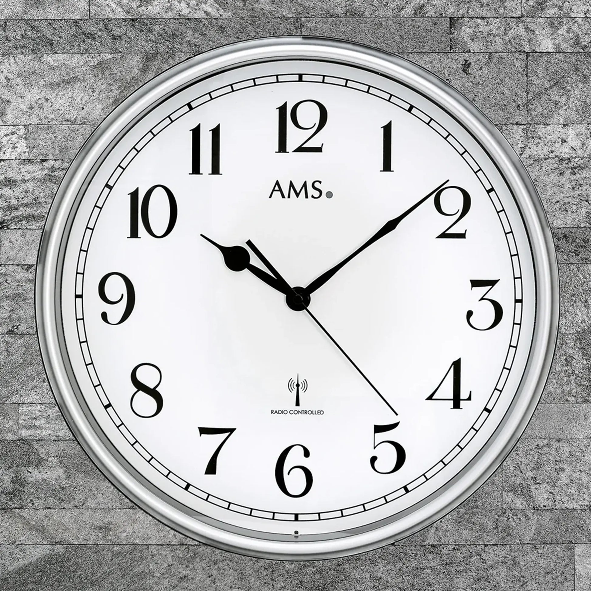 Nahansicht: AMS Funk-Wanduhr mit Funksymbol, weißem Ziffernblatt und Anthrazitrahmen