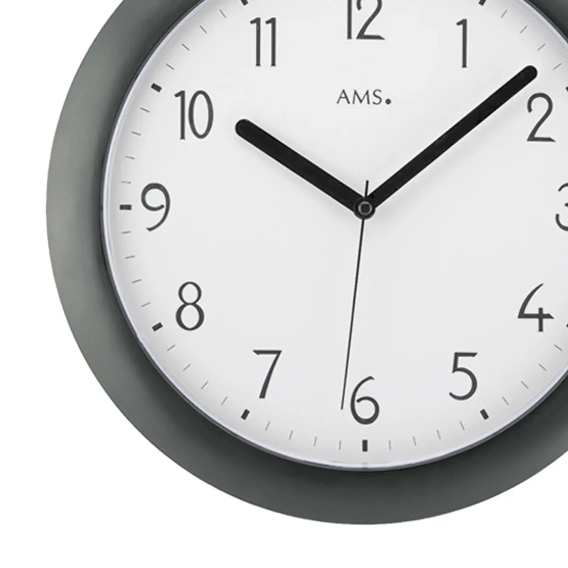 Detail der Funk-Wanduhr: weißes Ziffernblatt, schwarze Zeiger, dunkles Kunststoffgehäuse