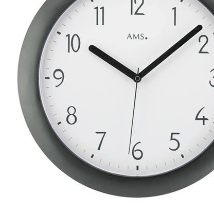 Detail der Funk-Wanduhr: weißes Ziffernblatt, schwarze Zeiger, dunkles Kunststoffgehäuse