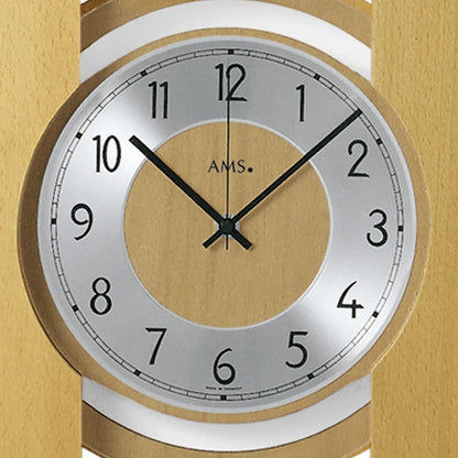 Detail der Wanduhr: weißes Ziffernblatt, schwarze Zeiger, helle Holzumrandung.
