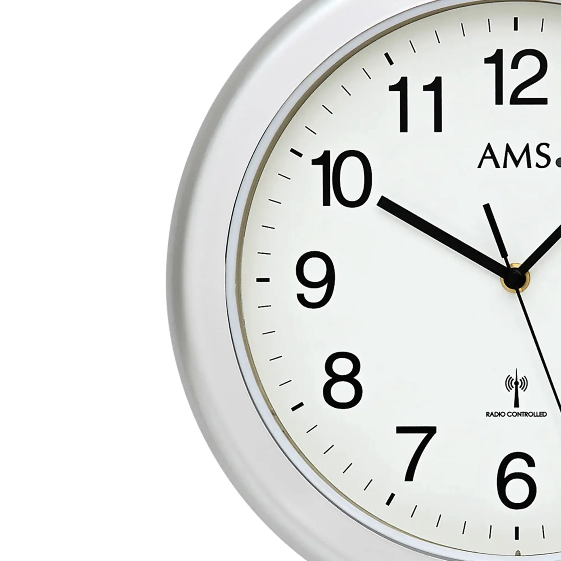 Nahansicht einer runden Wanduhr: silberner Rand, weißes Ziffernblatt, schwarze Zeiger, AMS