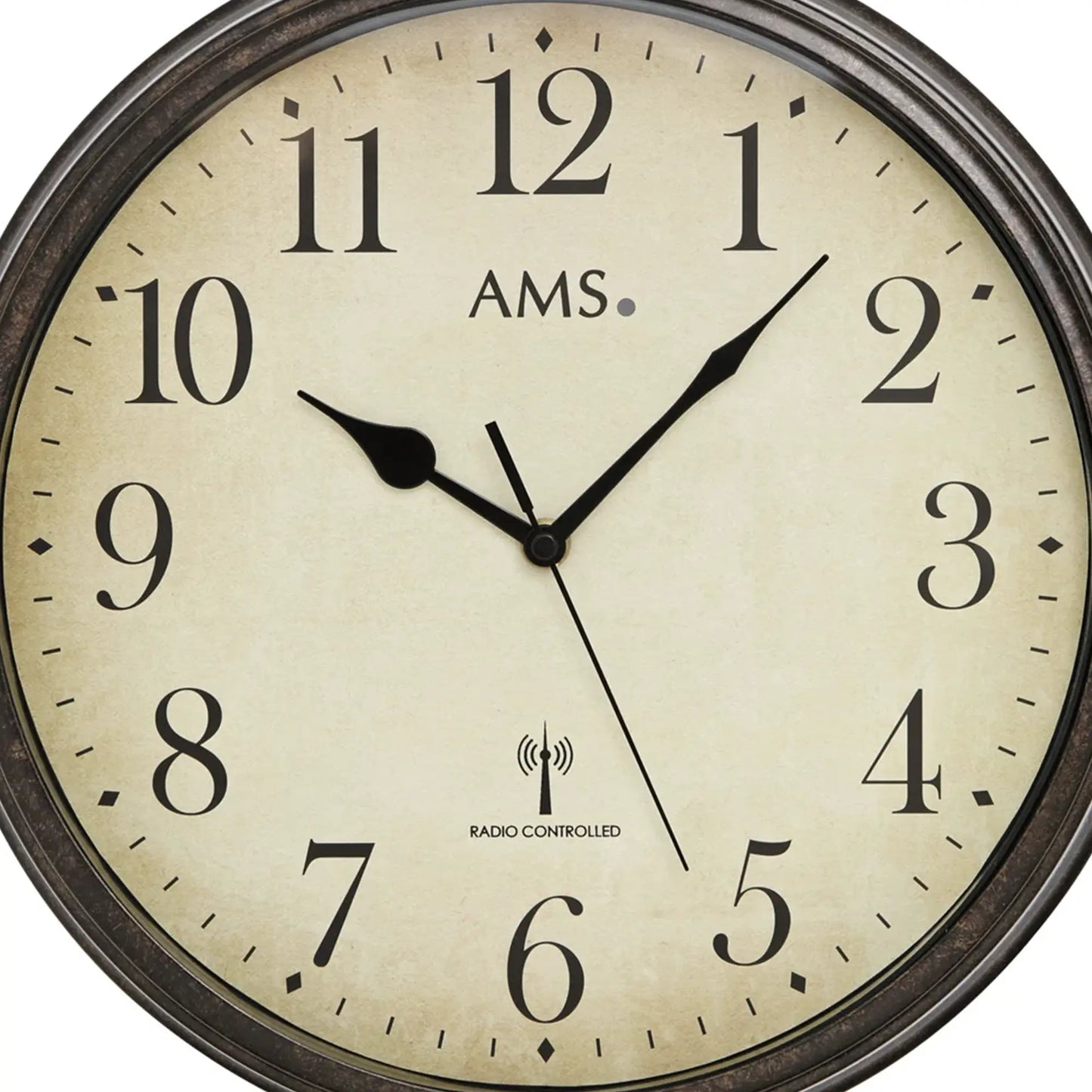 Nahaufnahme: AMS Wanduhr mit beigem Zifferblatt, schwarzen Zeigern und Funk-Logo
