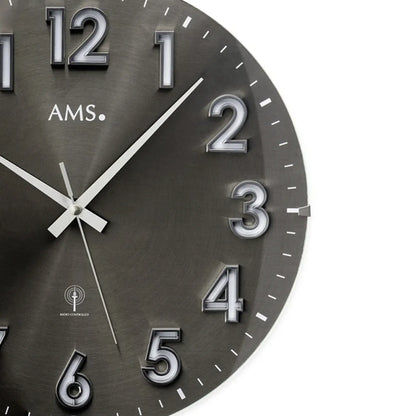 Detailansicht der AMS Funk-Wanduhr: dunkles Zifferblatt mit Ziffern 2–5 und Metallzeigern