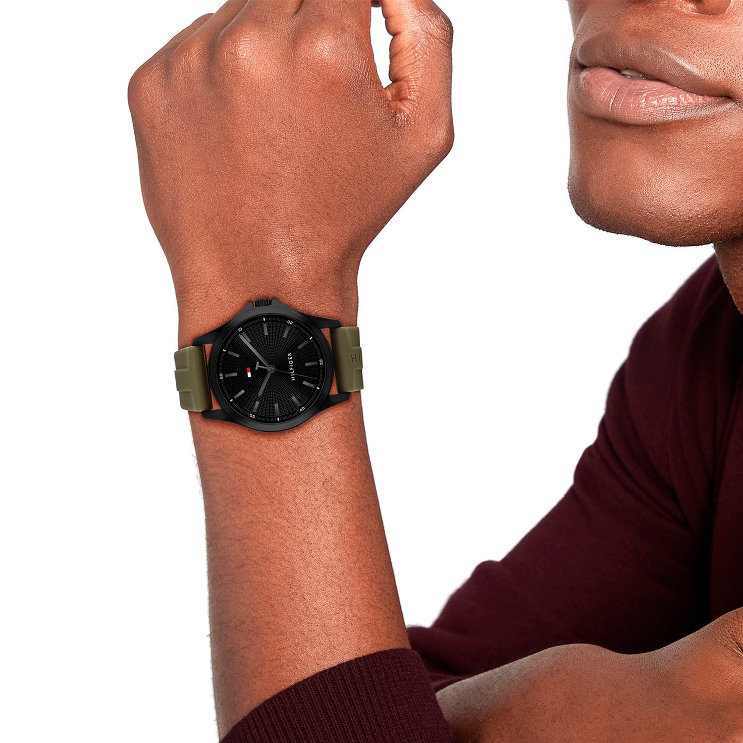 Herrenuhr mit schwarzem Zifferblatt und olivgrünem Silikonarmband am Handgelenk