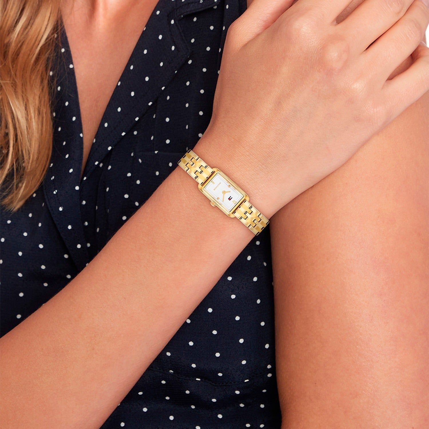 Tommy Hilfiger Damenuhr mit goldenem Armband am Handgelenk getragen