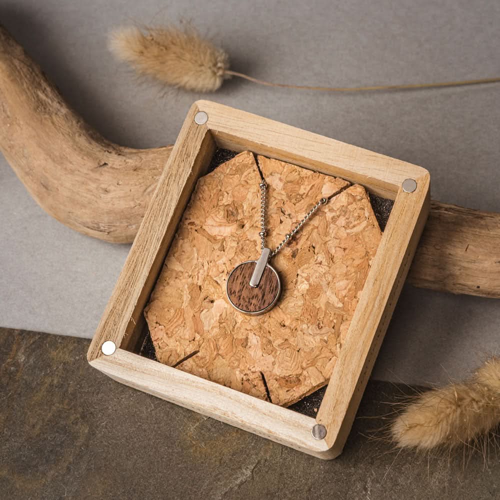 "Collar con colgante redondo de madera en bandeja rectangular de madera"