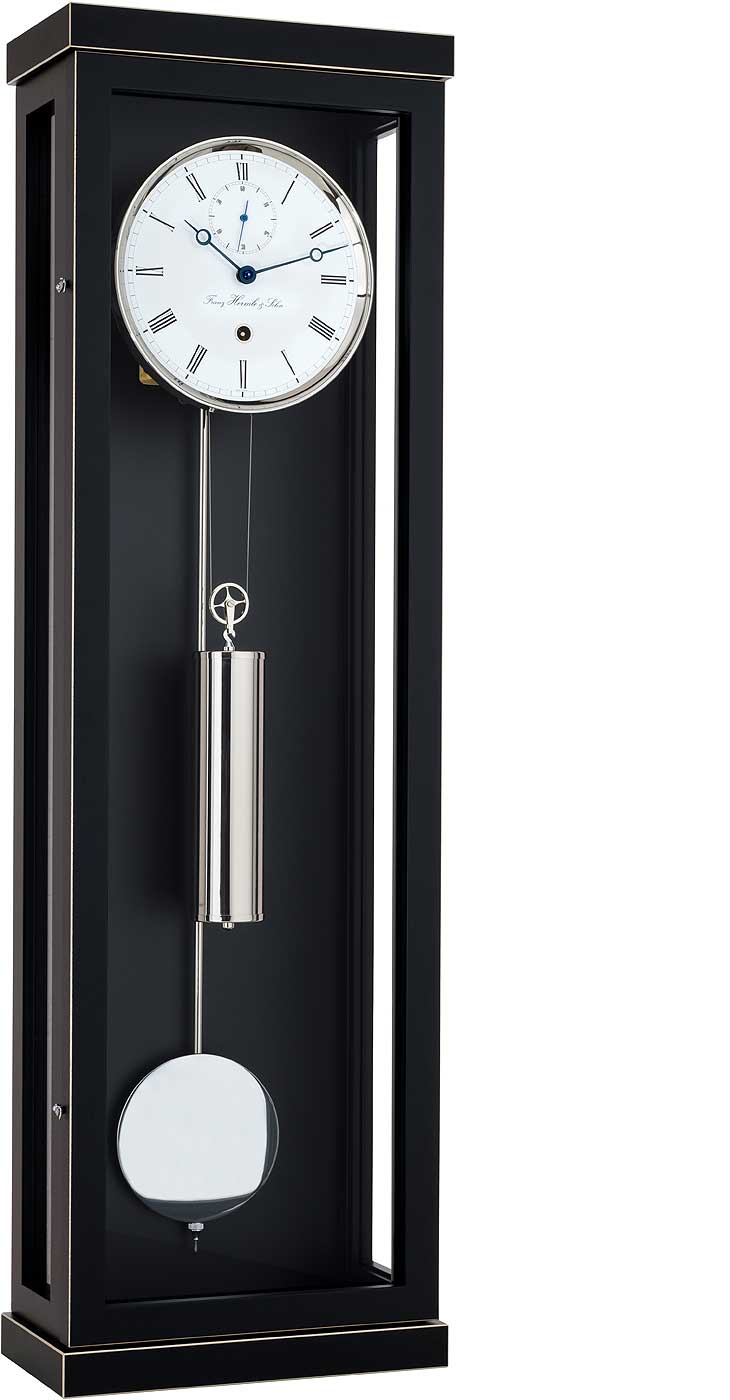Reloj de pared negro con esfera redonda blanca, frontal de cristal y pesa de arrastre visible.
