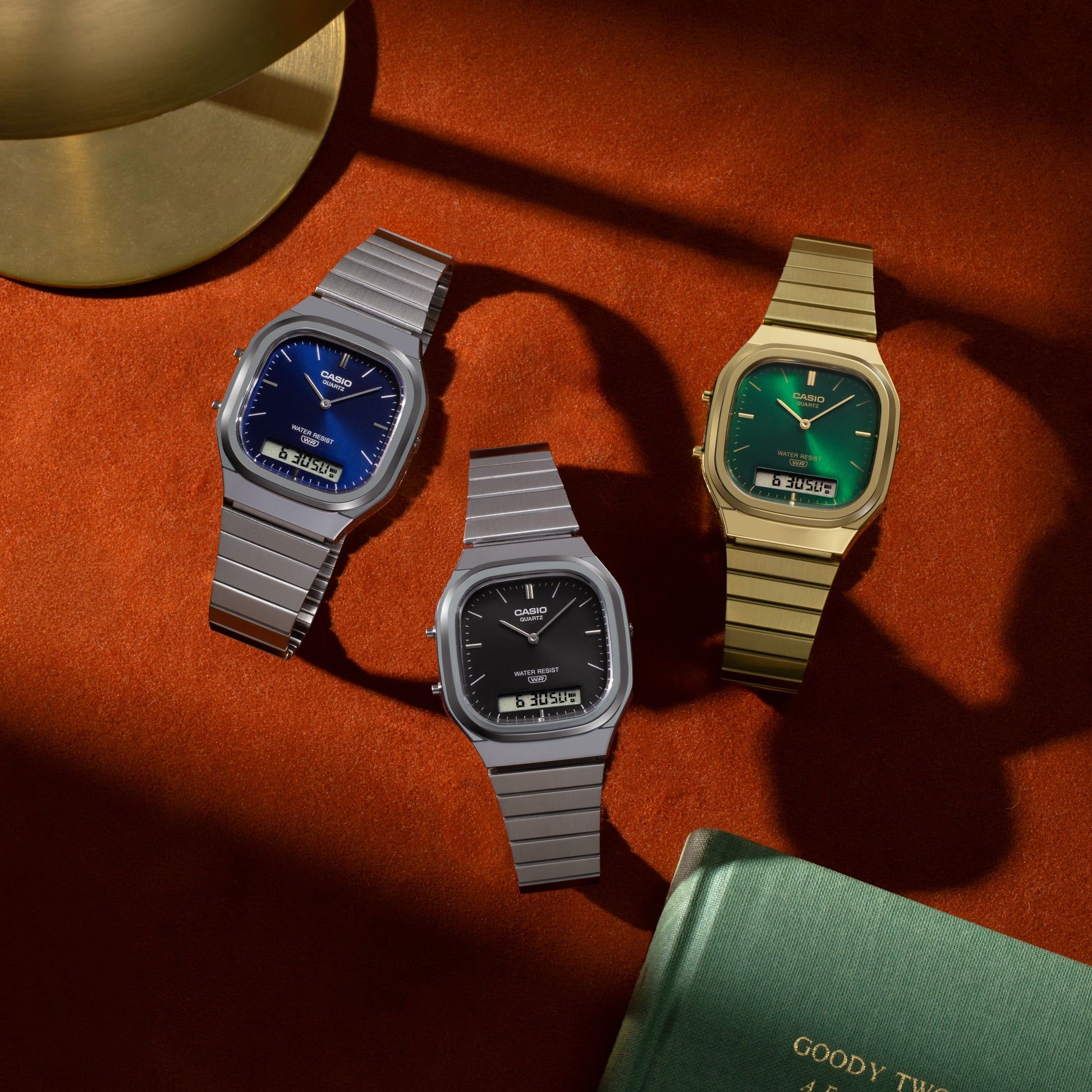 Drei Casio Armbanduhren mit Metallband: blaues, schwarzes und grünes Zifferblatt