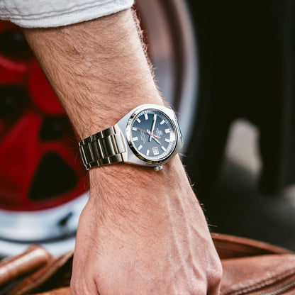 Herrenarmbanduhr am Handgelenk mit Edelstahlarmband und schwarzem Zifferblatt