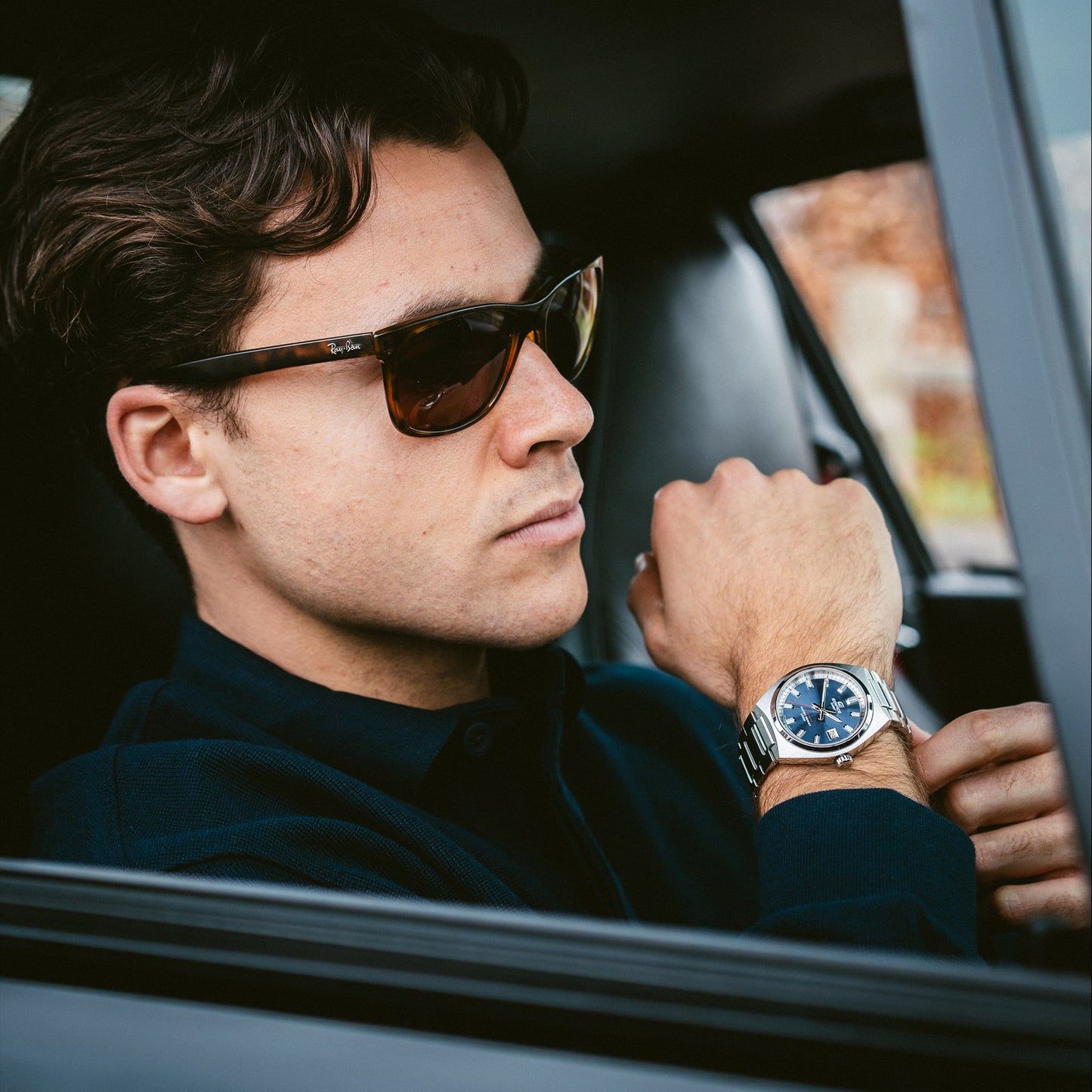 Casio Edifice Herrenuhr am Handgelenk im Auto, blaues Zifferblatt und Edelstahlgehäuse