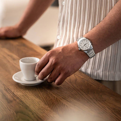 Herrenarmbanduhr am Handgelenk mit silbernem Metallband und hellem Automatik-Zifferblatt