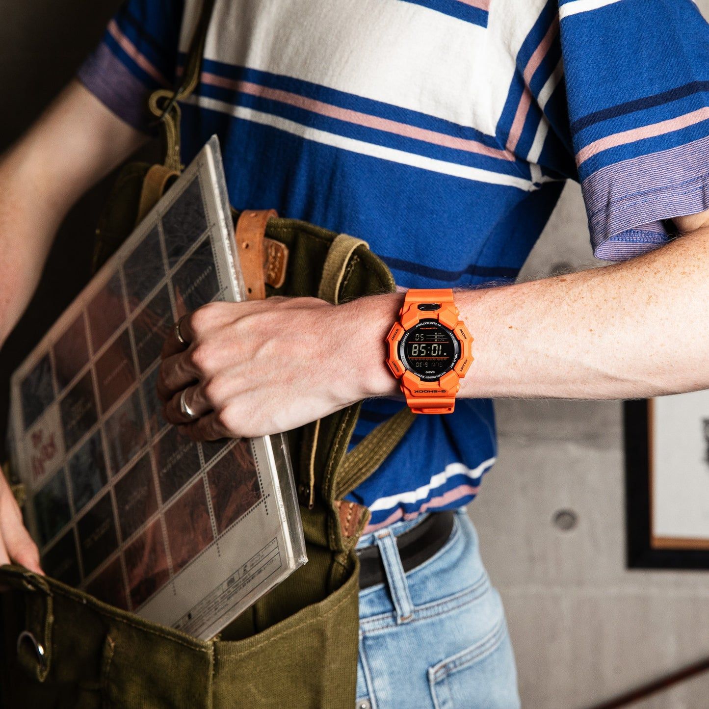Casio G-Shock Uhr am Handgelenk, orangefarbenes Gehäuse am Handgelenk sichtbar
