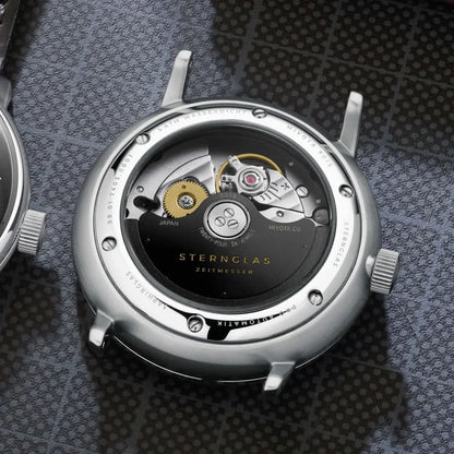 Fondo de la pulsera para hombre con movimiento automático visible en la tapa redonda de la caja