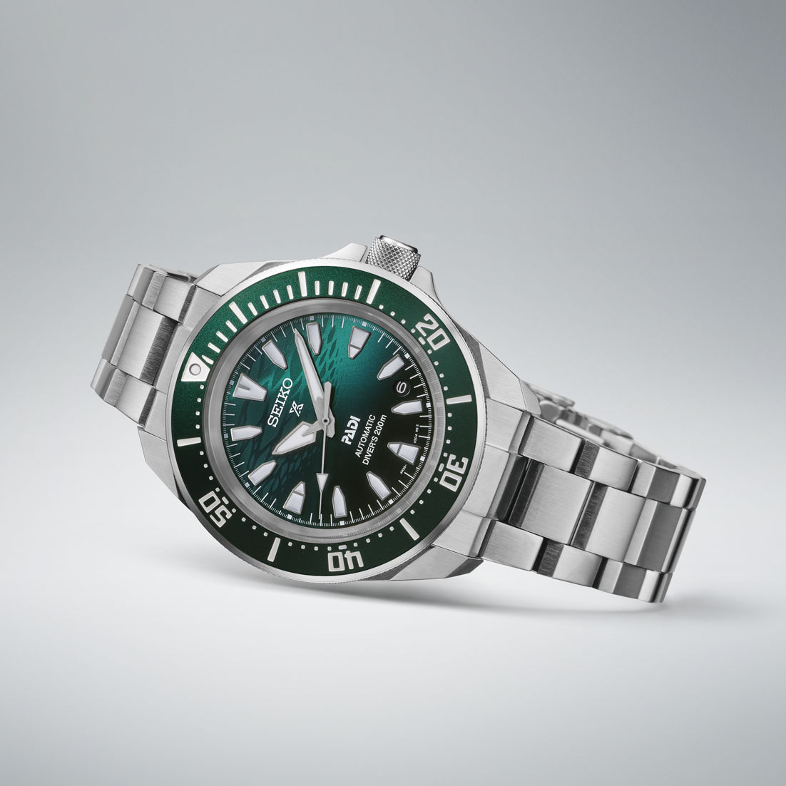 Reloj de hombre en diagonal con esfera verde, caja de acero plateado y pulsera ancha