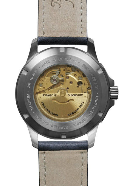 Vista trasera de reloj de pulsera para hombre con correa de cuero beige y movimiento visible en la caja