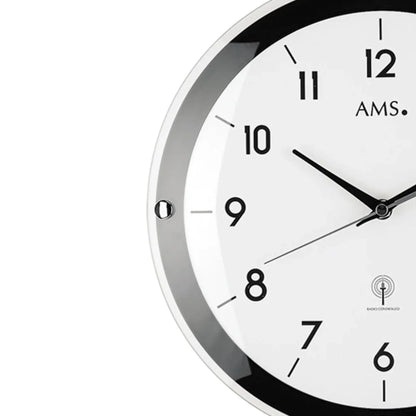Wanduhr mit schwarzem Rahmen, weißem Zifferblatt, Zeigern und Funkuhr-Logo