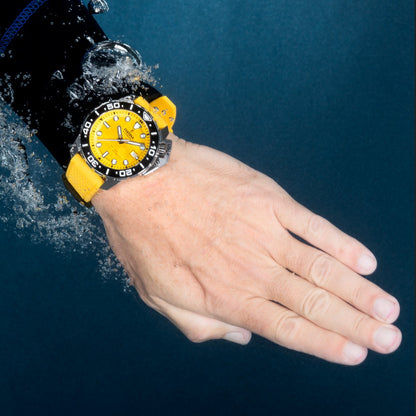 Herrenuhr am Handgelenk mit orangefarbenem Zifferblatt und gelbem Silikonarmband