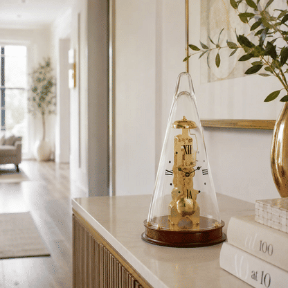 Reloj de mesa con campana de cristal y mecanismo dorado, base de madera marrón