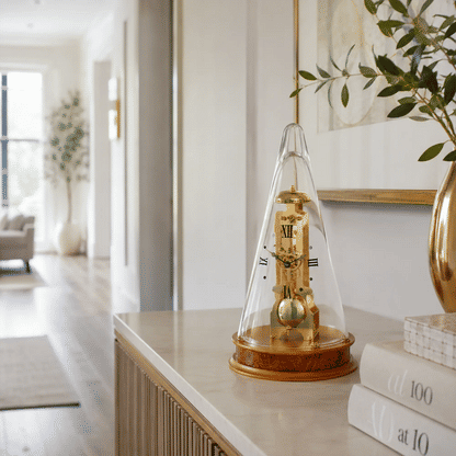 Reloj de mesa con campana de cristal, mecanismo dorado y base redonda de madera