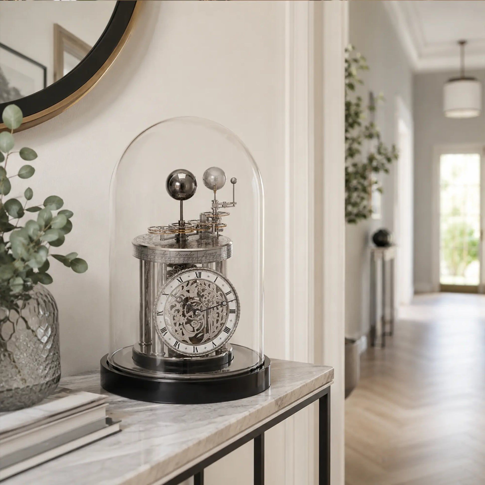 Reloj de mesa con campana de cristal, esfera plateada y base negra sobre tablero