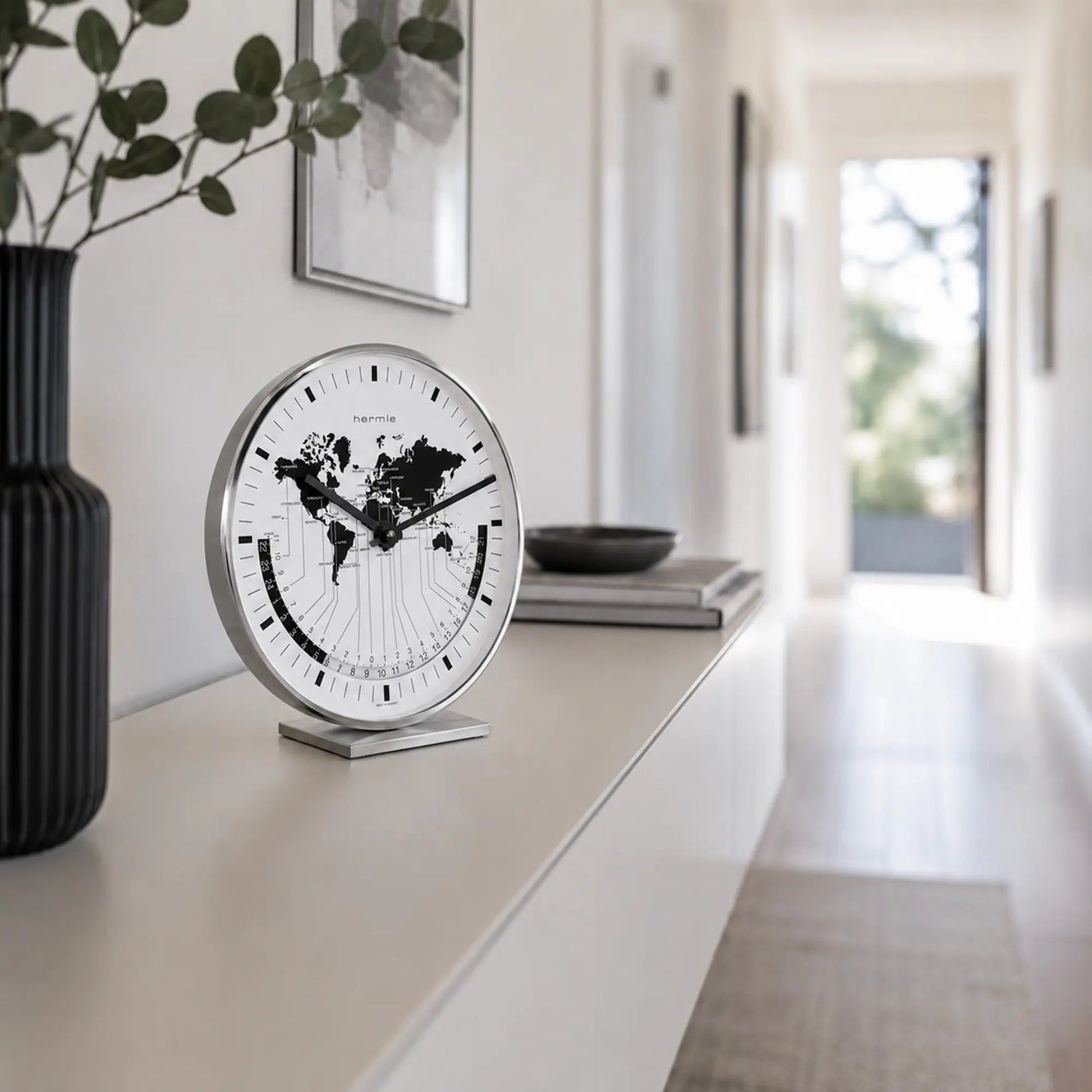Reloj de mesa metálico con mapa del mundo en esfera blanca y manecillas negras
