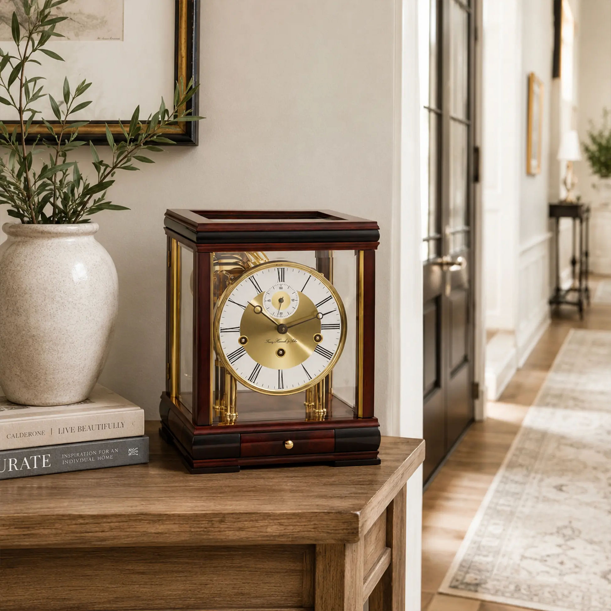Reloj de mesa de caoba con frente de cristal y columnas doradas, esfera redonda