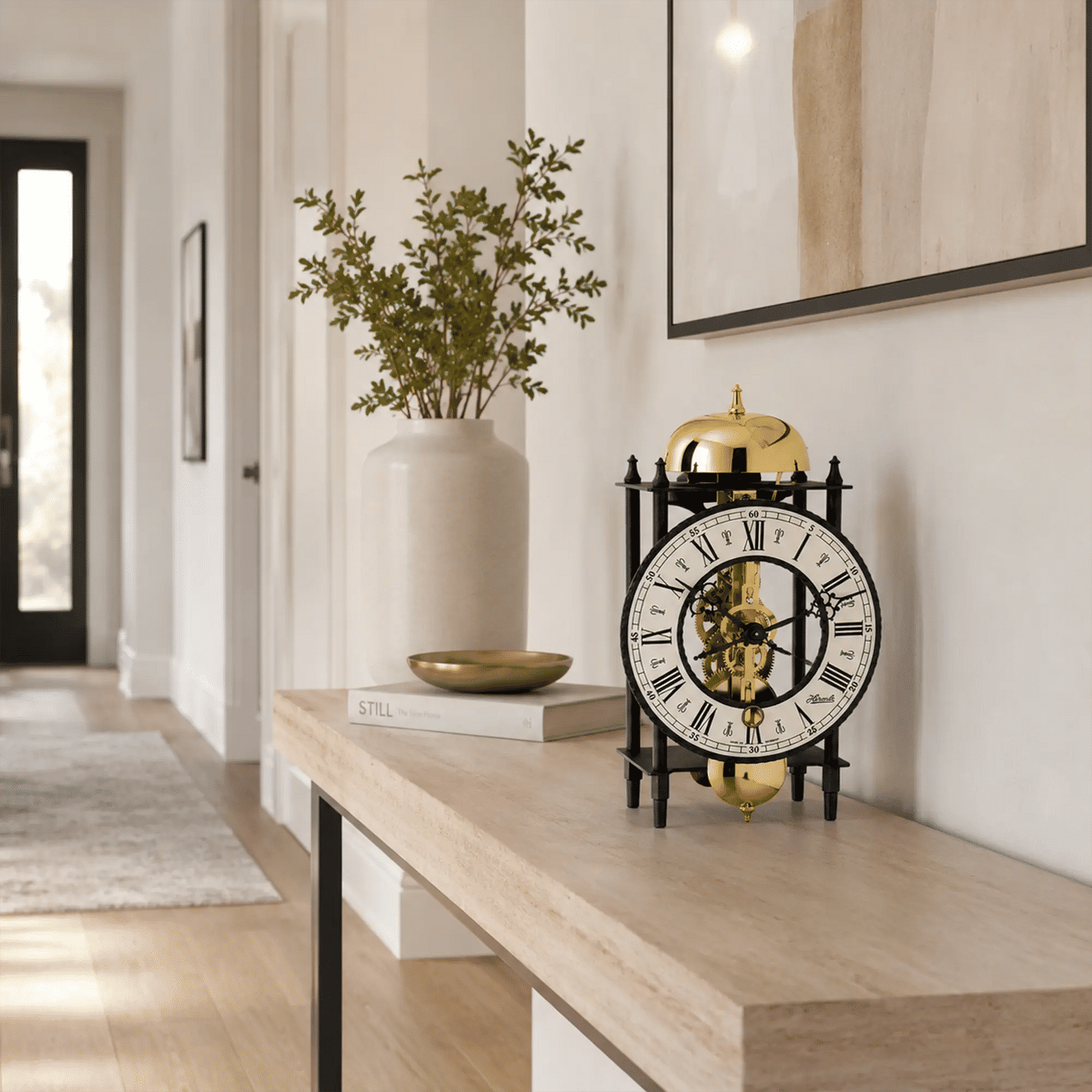 Reloj de mesa mecánico sobre consola de madera, esfera redonda con movimiento esqueleto dorado