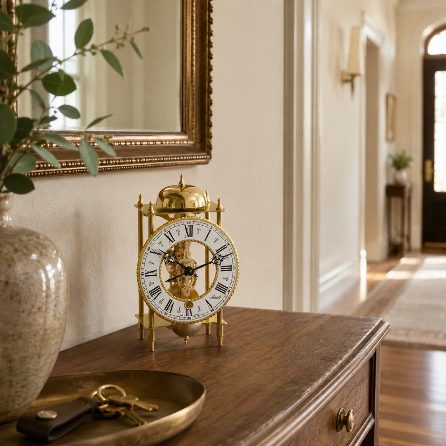 Reloj de mesa con caja de metal dorado y esfera romana sobre superficie de madera