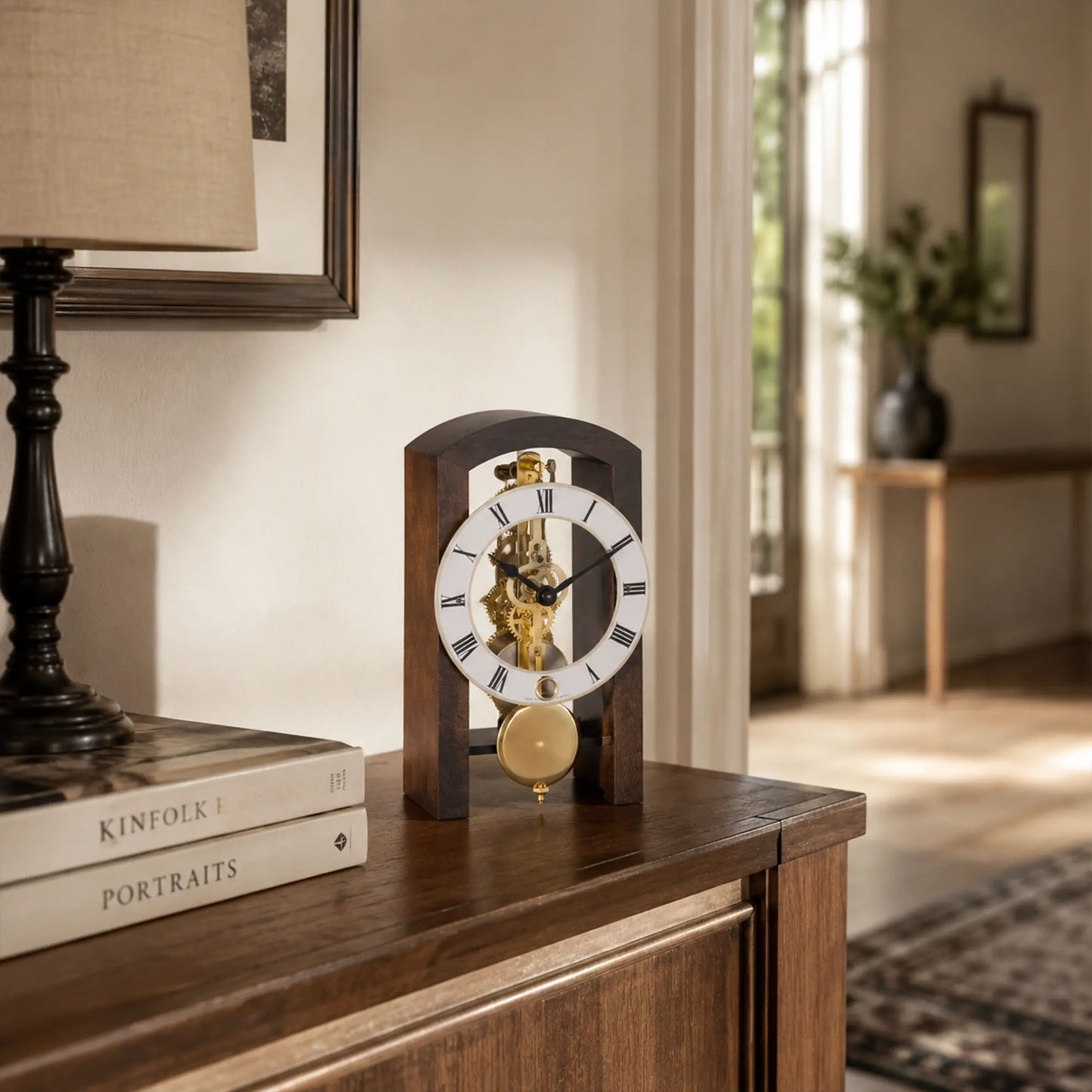 Reloj de mesa sobre superficie de madera con mecanismo de latón expuesto, números romanos y pesa de péndulo