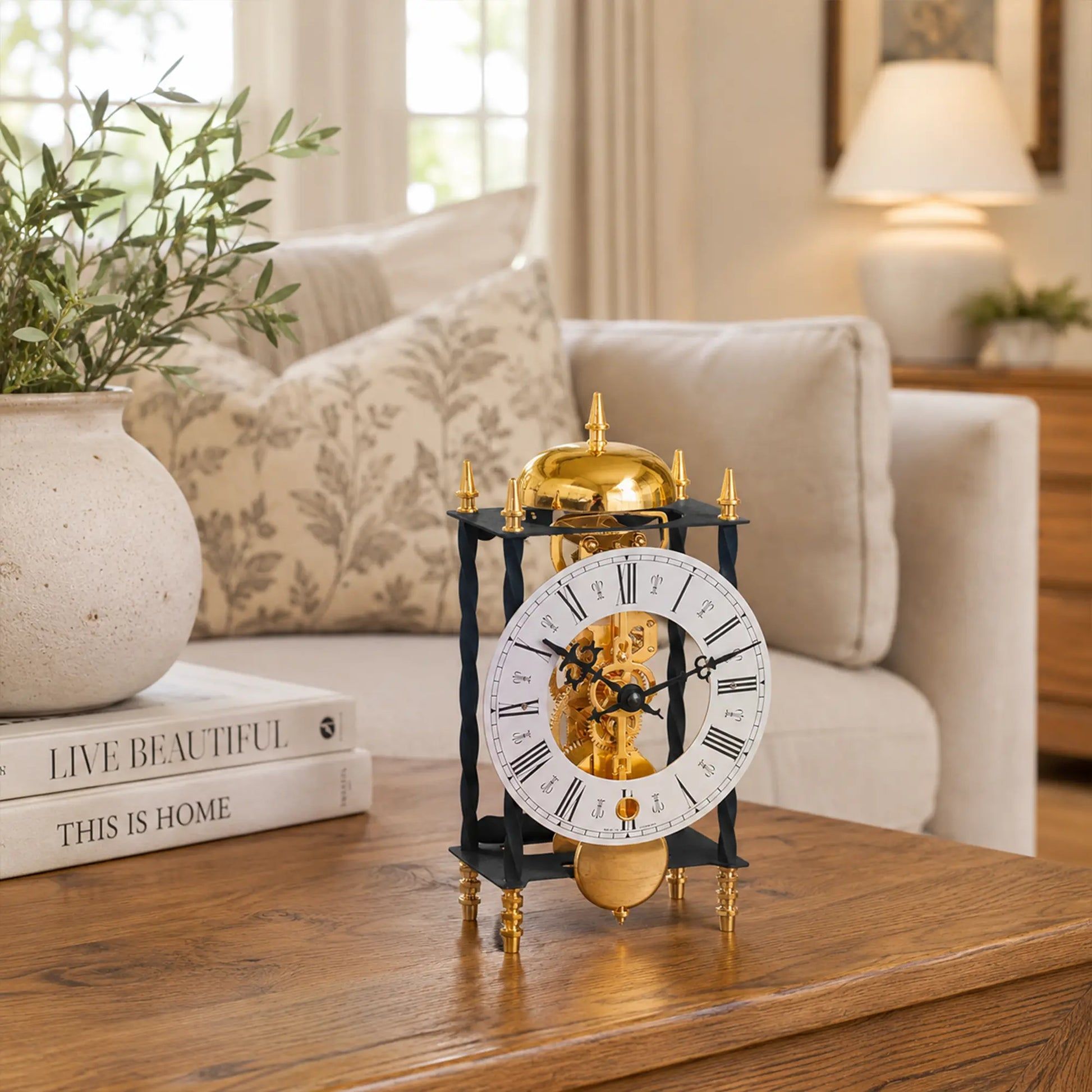 Reloj de mesa mecánico con esfera redonda blanca, péndulo dorado y base negra