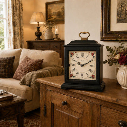 Reloj de mesa negro con carcasa de madera, asa dorada y esfera con estampado floral