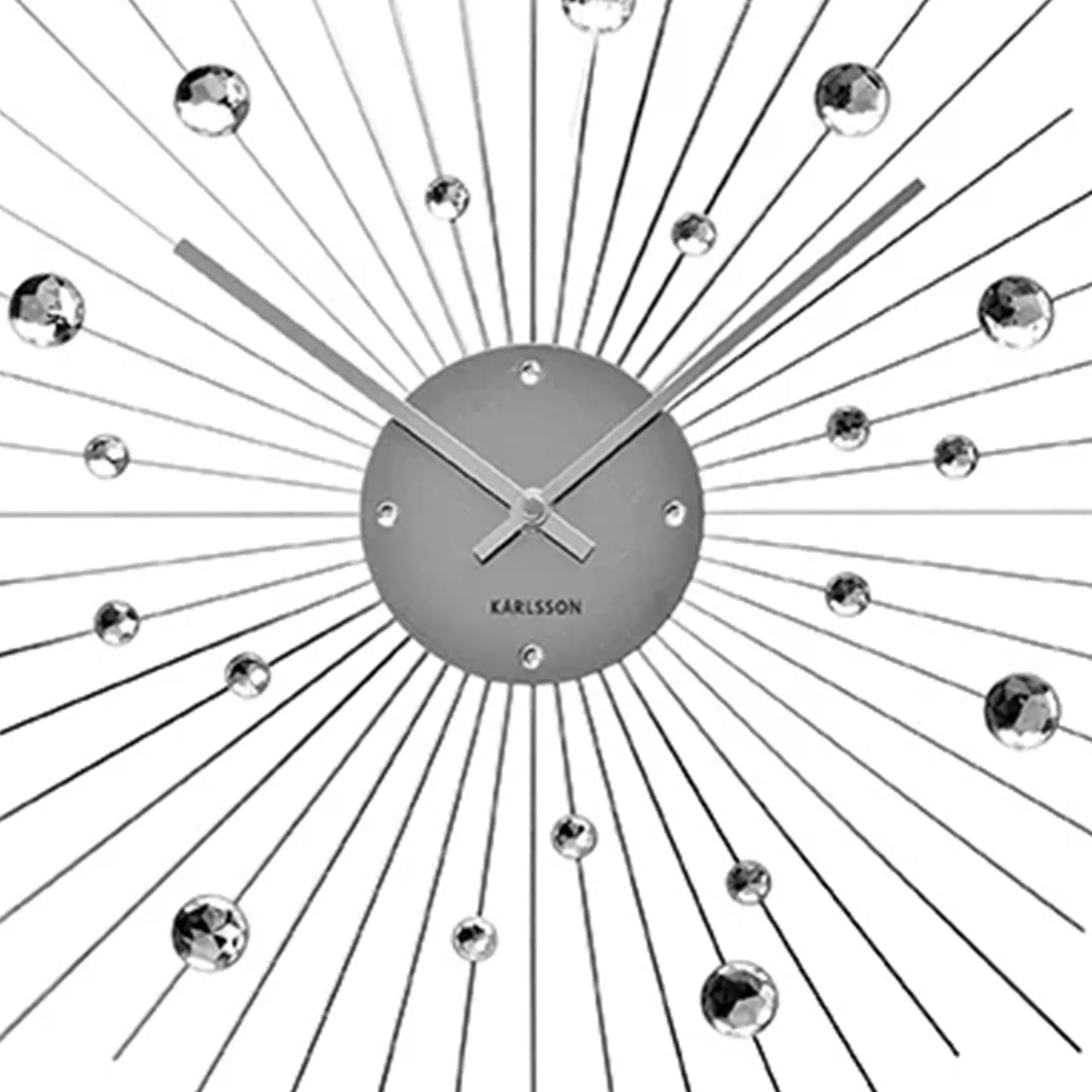 Nahaufnahme: Wanduhr-Uhrscheibe mit Karlsson-Schriftzug und Sonnenstrahlen aus Draht.