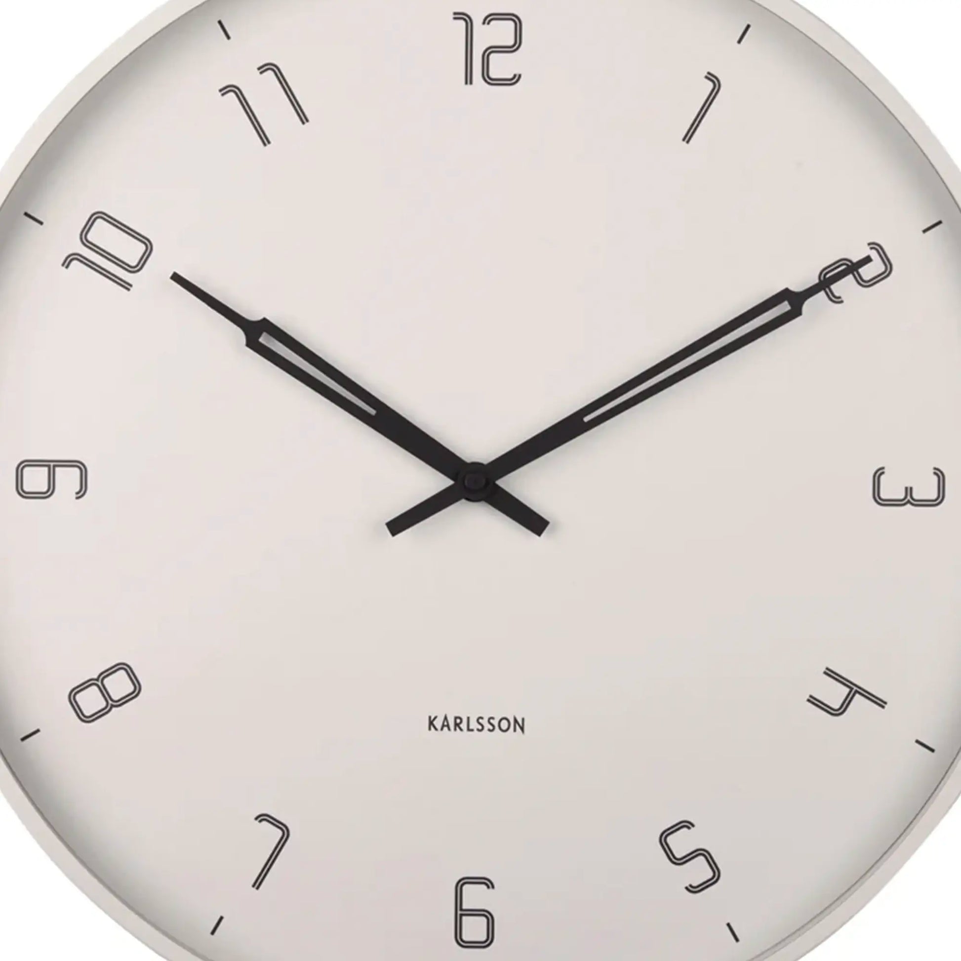 Nahaufnahme der Wanduhr: helles Zifferblatt mit schwarzen Zeigern und großen Ziffern.