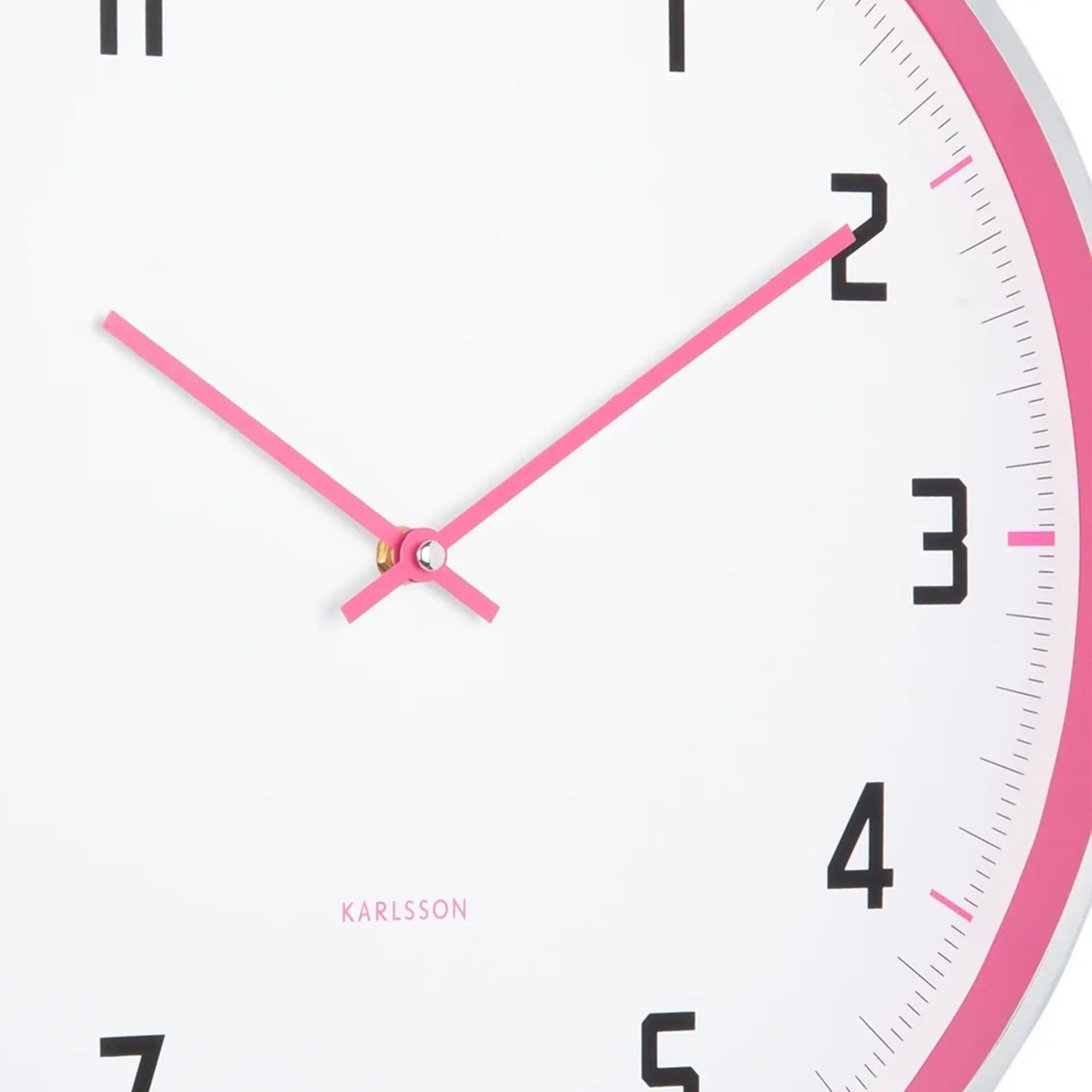 Detailansicht der Wanduhr: pinke Zeiger, weißes Ziffernblatt mit schwarzer Ziffer 2