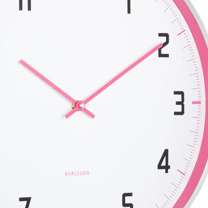 Detailansicht der Wanduhr: pinke Zeiger, weißes Ziffernblatt mit schwarzer Ziffer 2