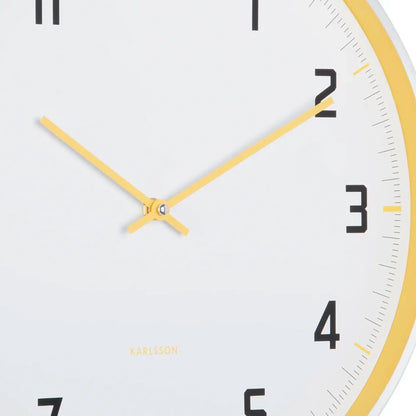 Nahaufnahme: Karlsson Wanduhr-Ziffernblatt mit gelben Zeigern und schwarzen Zahlen