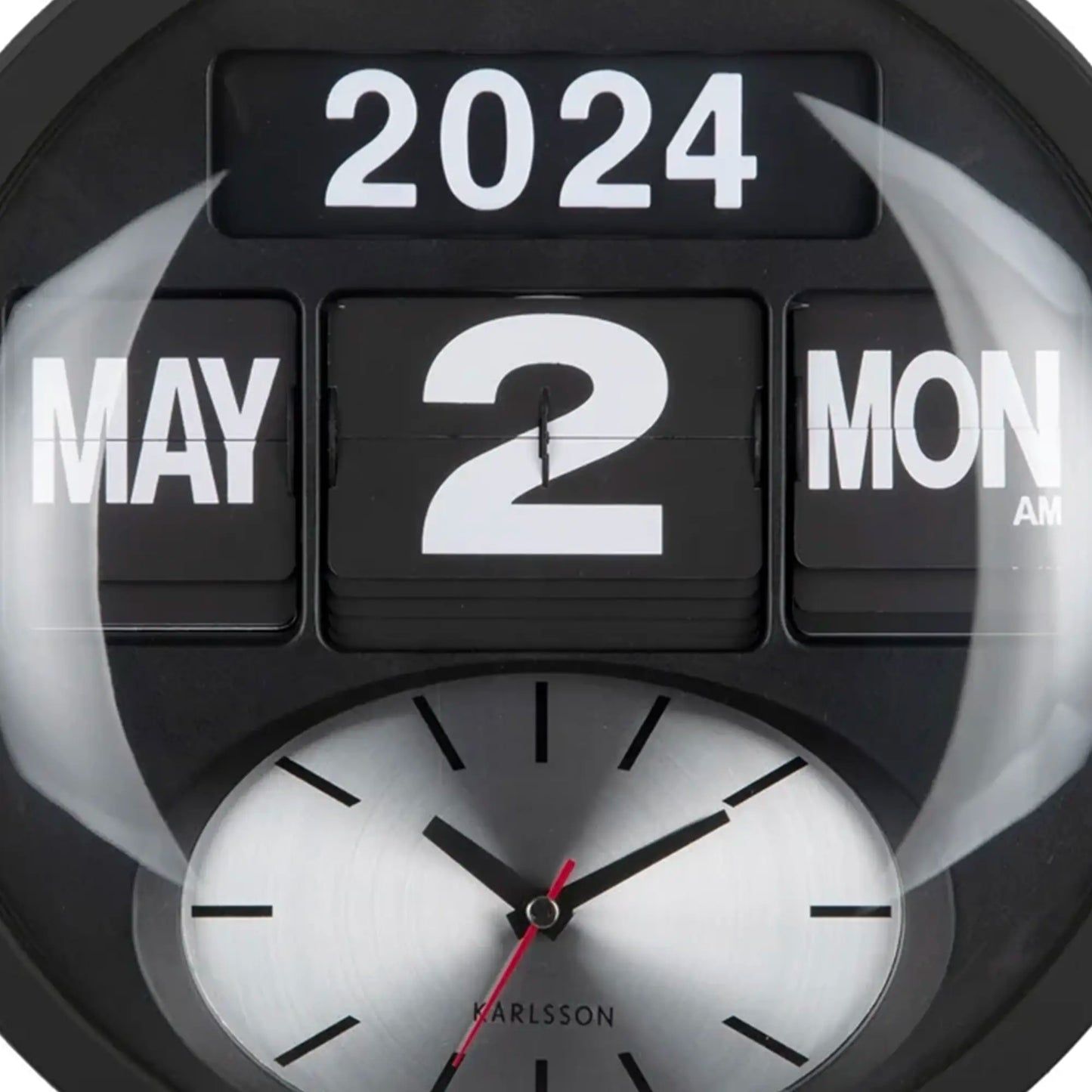 Nahaufnahme der schwarzen Wanduhr: Flip-Ziffern „2024 2“ und analoges Ziffernblatt