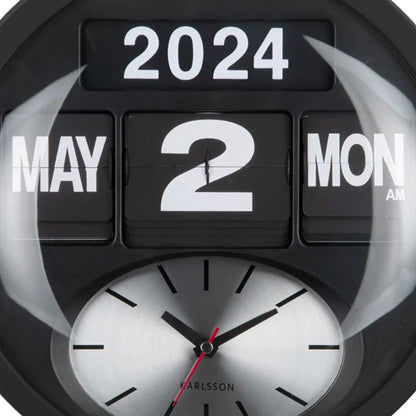 Nahaufnahme der schwarzen Wanduhr: Flip-Ziffern „2024 2“ und analoges Ziffernblatt