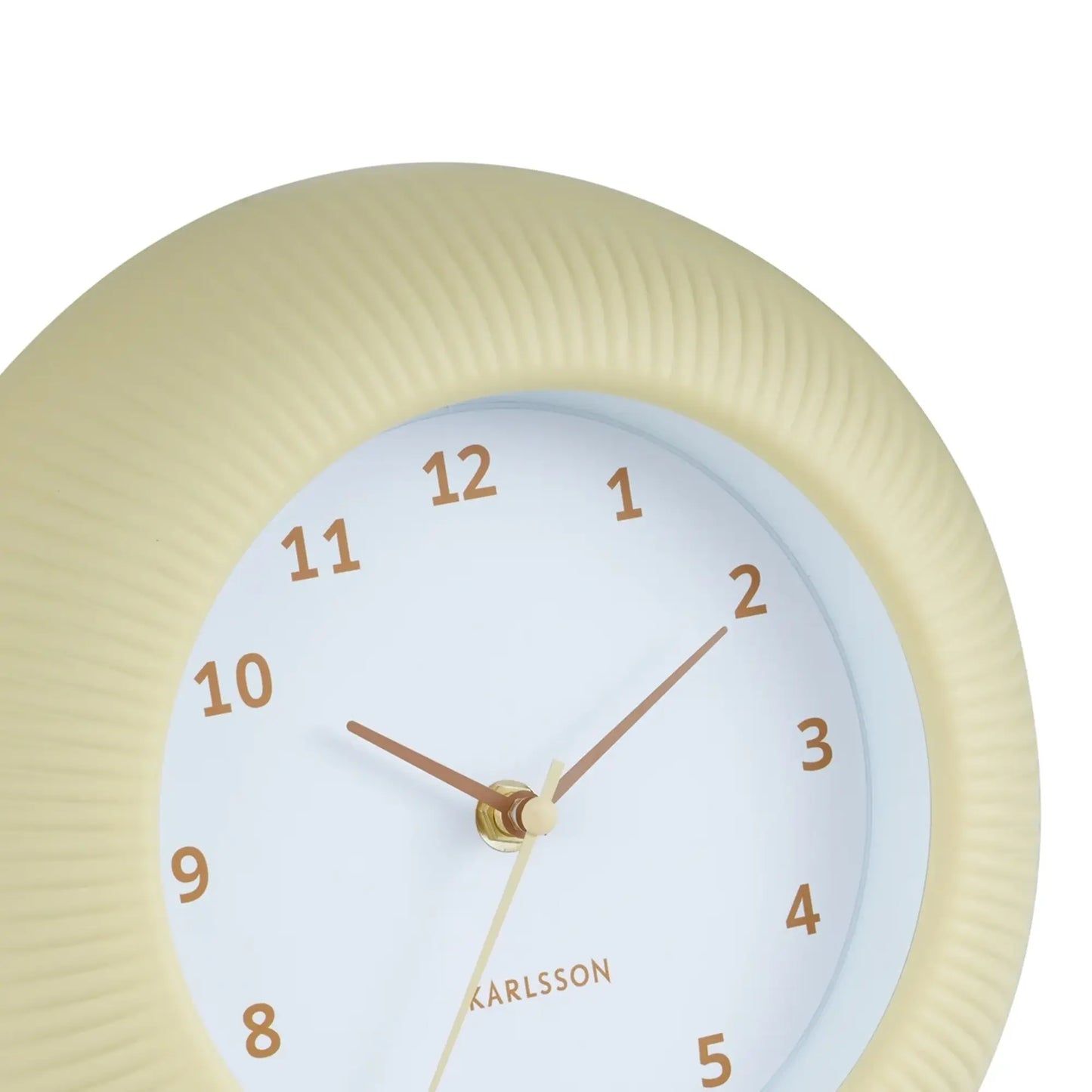Großaufnahme Wanduhr Softgelb: geriffelter Rand, goldene Zeiger und Ziffern