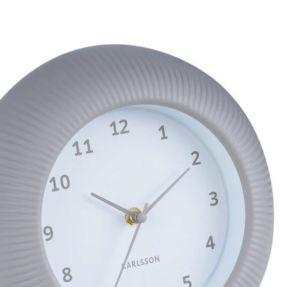 Warmgraue Wanduhr Nahansicht: geriffeltes Gehäuse, Ziffern und goldene Zeiger