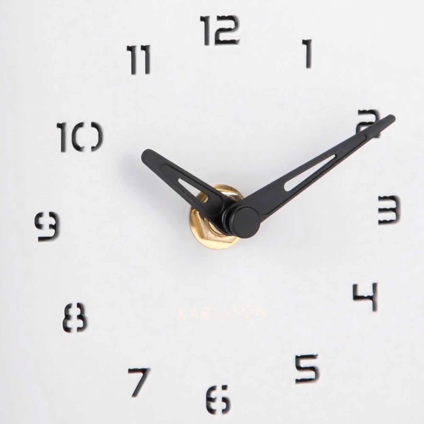 Nahaufnahme: Uhrzeiger und römische Ziffern auf weißem Zifferblatt der Wanduhr