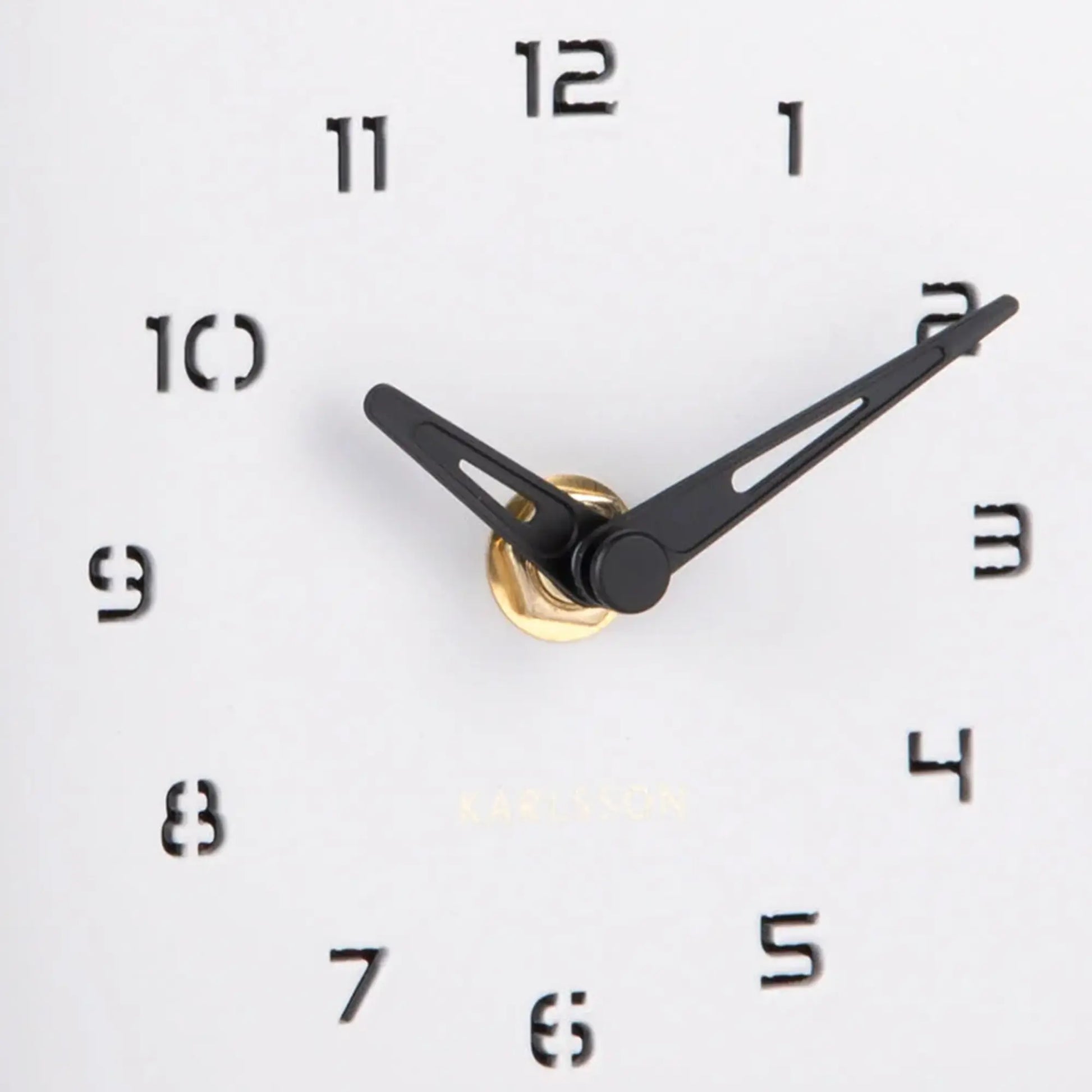 Nahaufnahme: Uhrzeiger und römische Ziffern auf weißem Zifferblatt der Wanduhr