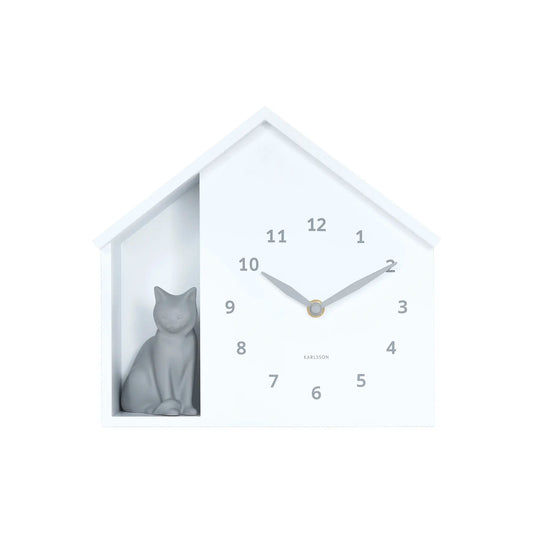 Weiße Wanduhr im Hausformat mit Katze im Fenster; Zeiger und Ziffern 1–12