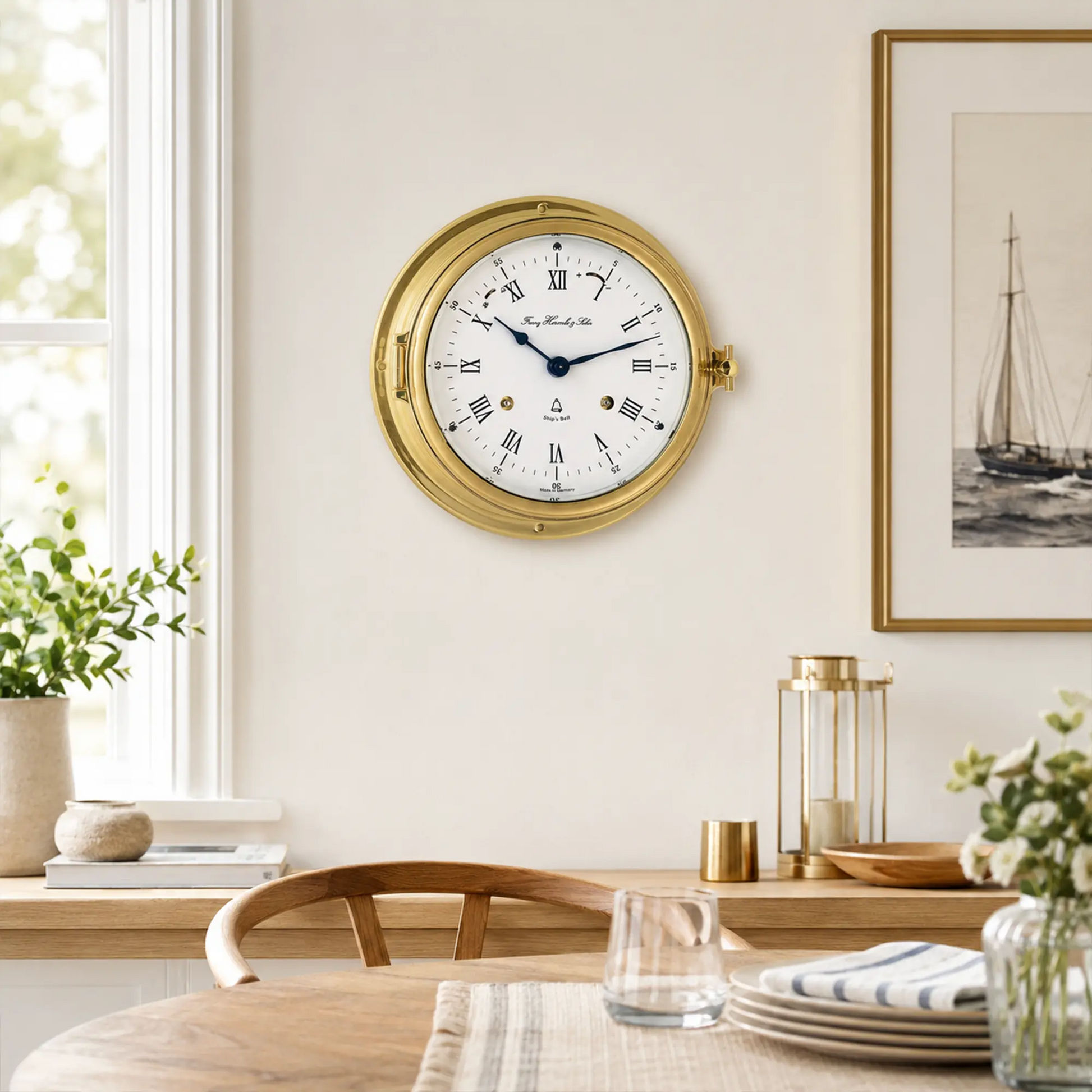 Reloj de pared redondo con caja de latón y esfera blanca, manecillas azules y números romanos.