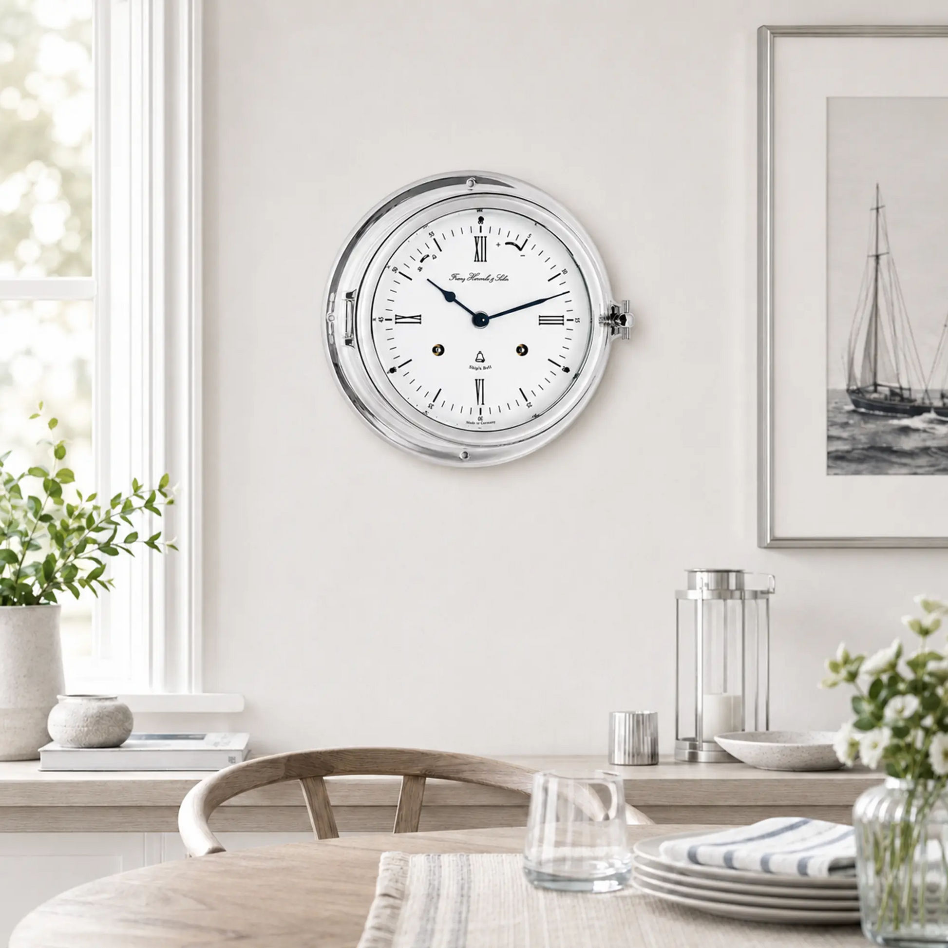 "Reloj analógico redondo con marco plateado y esfera blanca, manecillas azules"