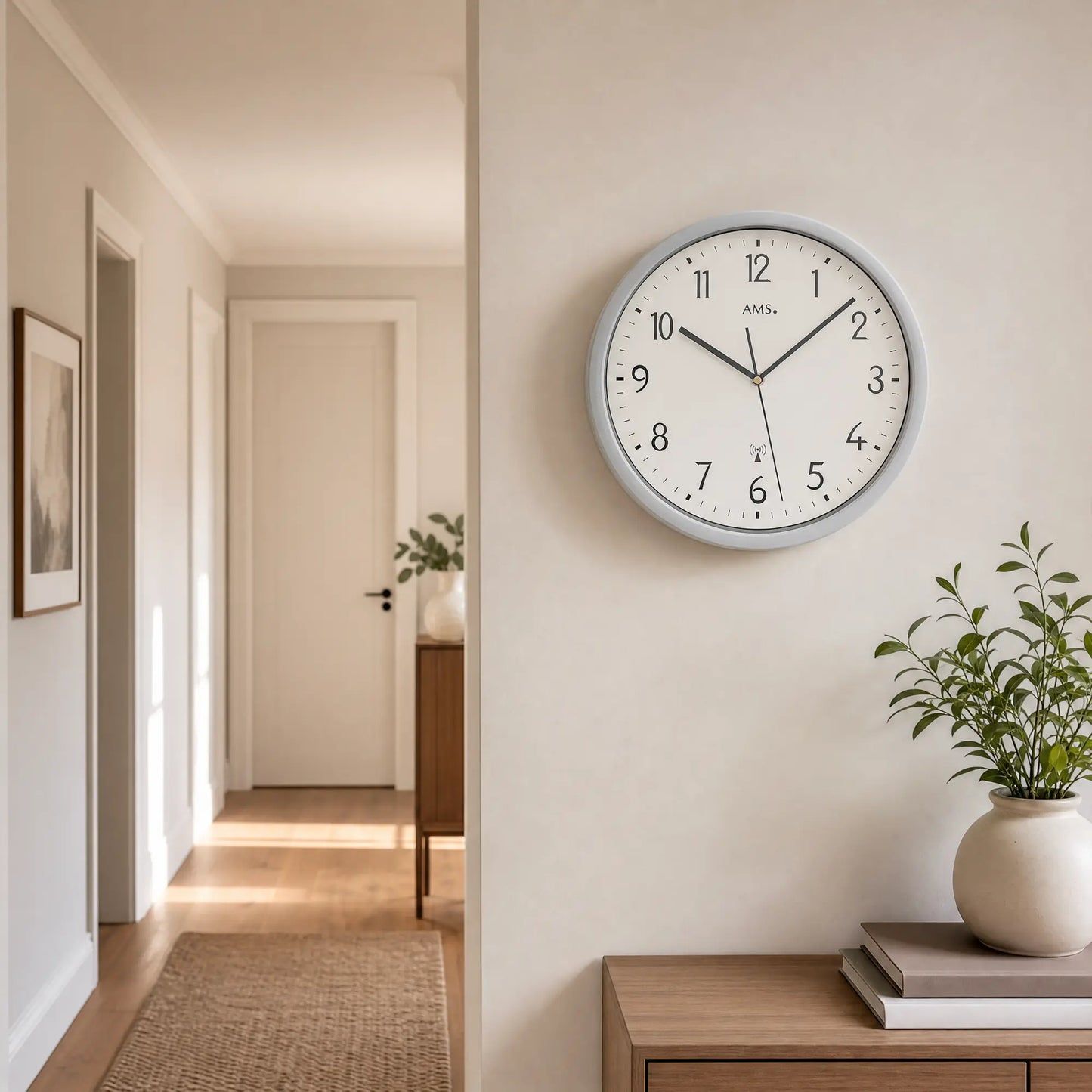 Funkuhr-Wanduhr mit weißem Zifferblatt und silbernem Rahmen an der Wand