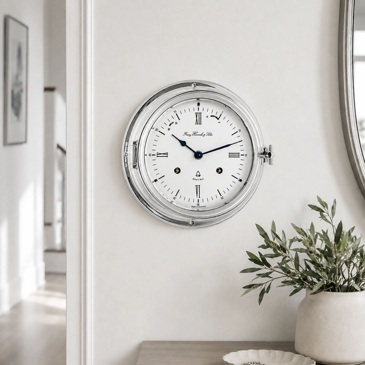 "Reloj de mesa analógico redondo con caja plateada y esfera blanca, manecillas azules"