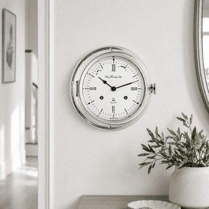 "Reloj de mesa analógico redondo con caja plateada y esfera blanca, manecillas azules"